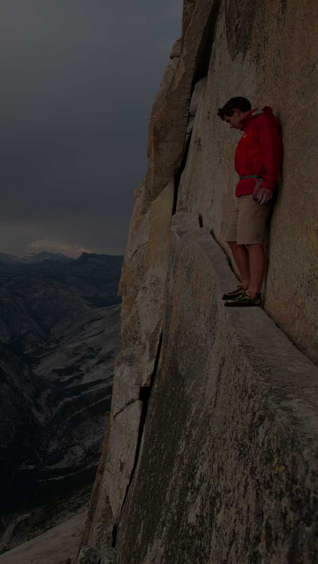 Climber, Alex Honnold, looks down on the Yosemite Valley from an exposed ledge.