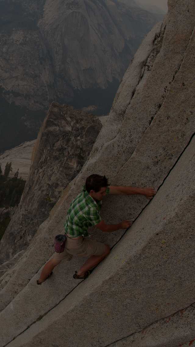 Climber, Alex Honnold, grips the granite wall on his free solo ascent of Half Dome in Yosemite National Park.