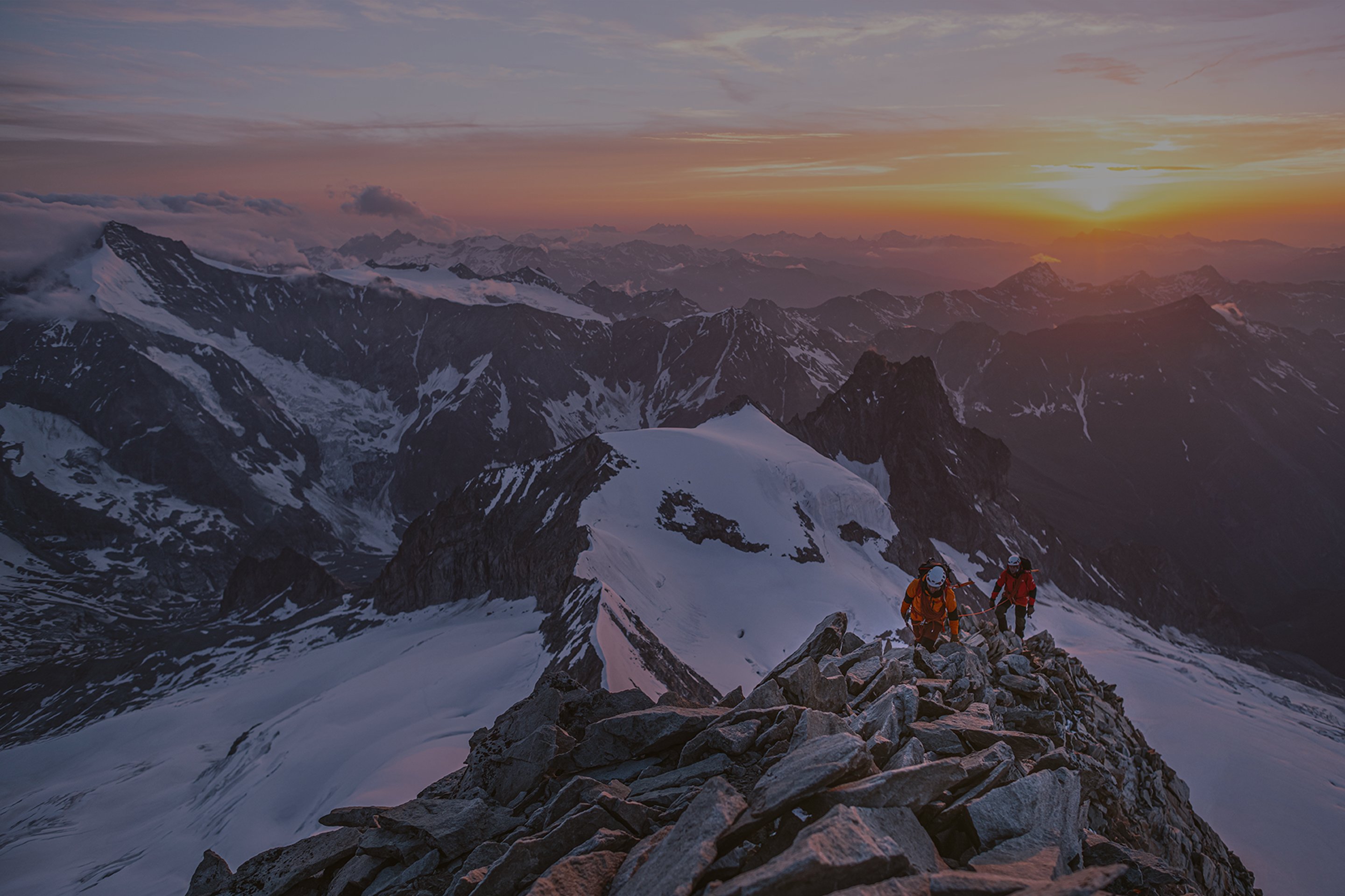 At sunrise, a pair of mountaineers make the final push towards the summit.