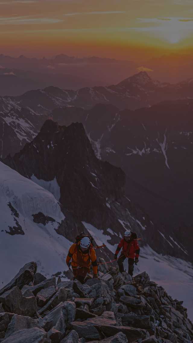 At sunrise, a pair of mountaineers make the final push towards the summit.