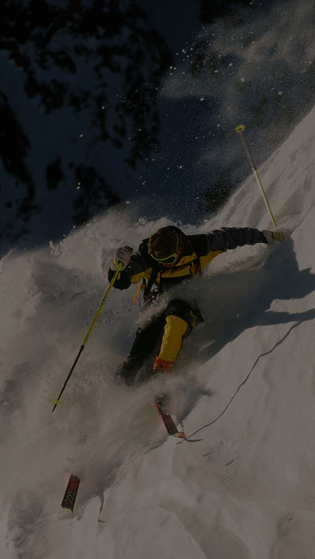 Professional skier, Scot Schmidt, makes a steep descent of a near vertical slope.