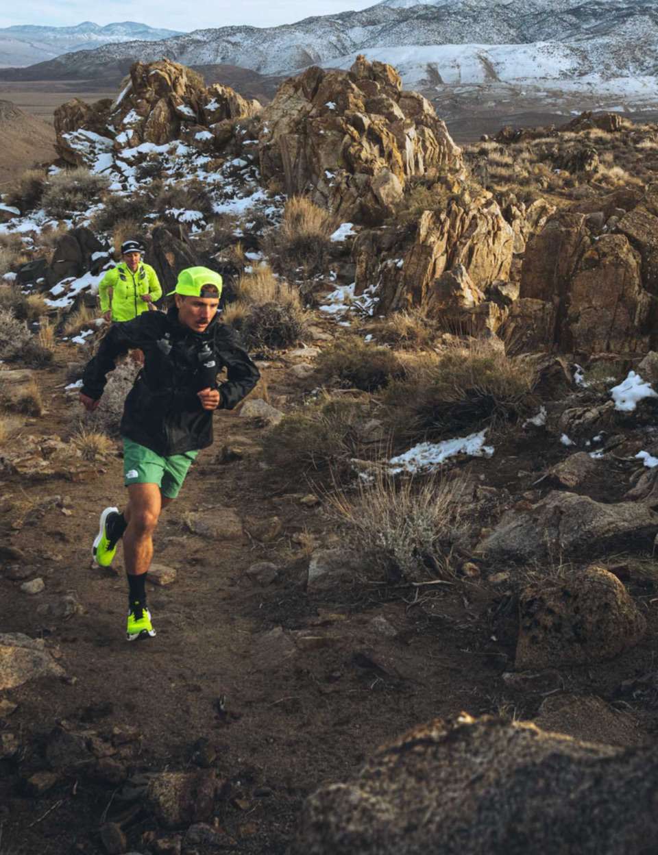 Two runners power to the summit of a high alpine trail.