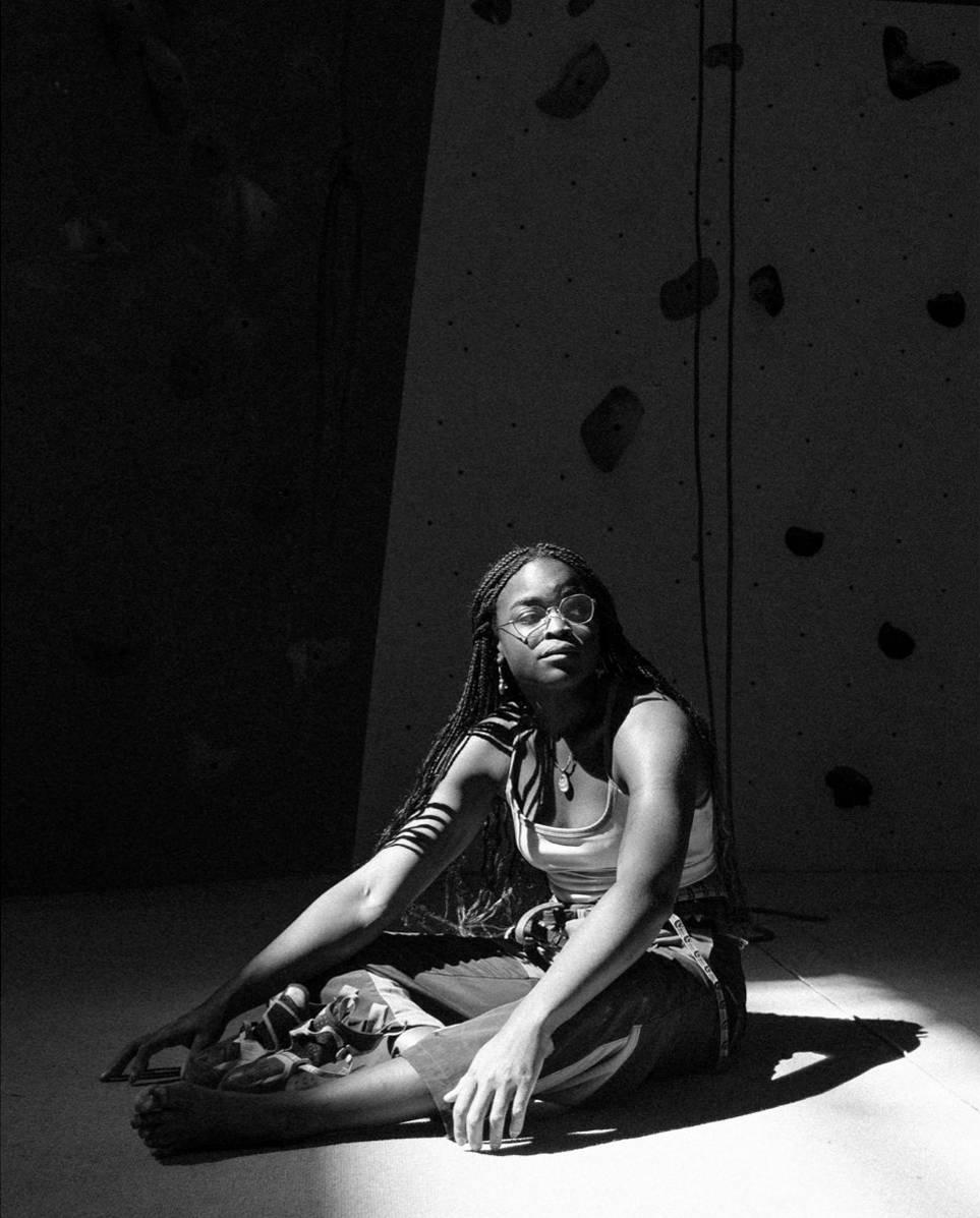 Team athlete Marie-Louise sits on a climbing mat.